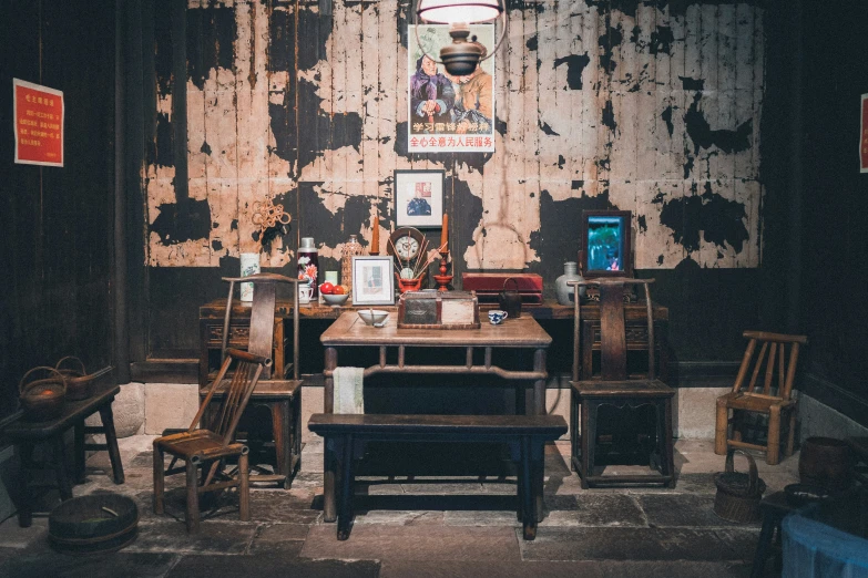 a rustic wooden table and chairs are in a dimly lit area