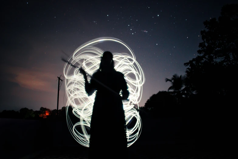 a woman standing outside with a ball made from light