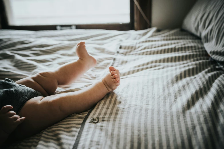 a man is sitting on a bed looking up at soing in his hand