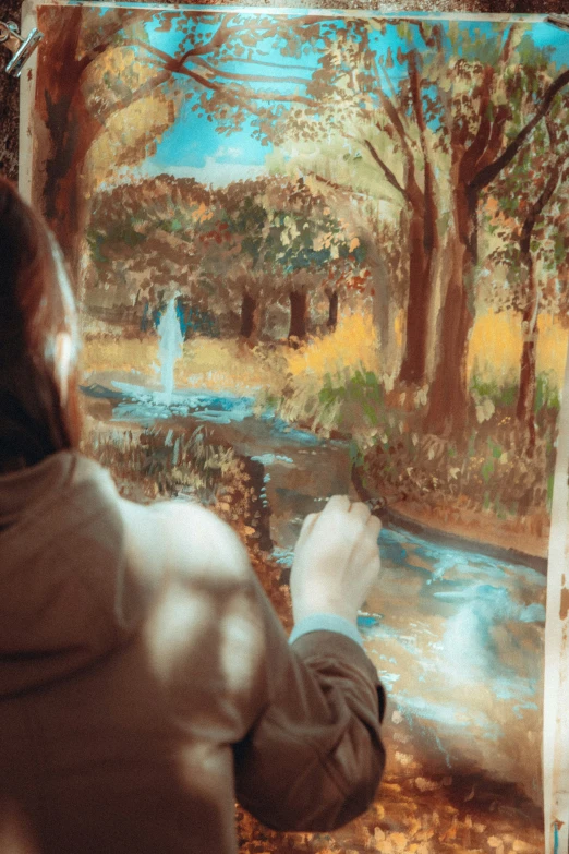 an artist looking at a landscape in his studio