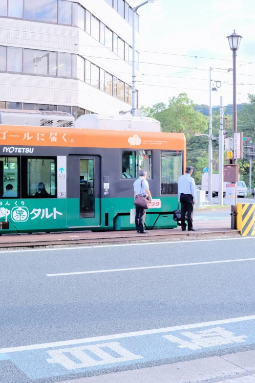 three people boarding a metro bus at a stop in the city