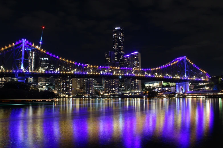 a colorful bridge spans a large city