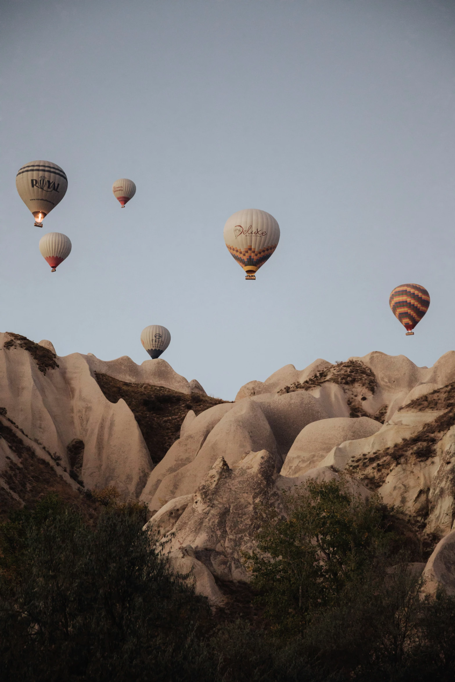 a group of  air balloons are flying over a mountain