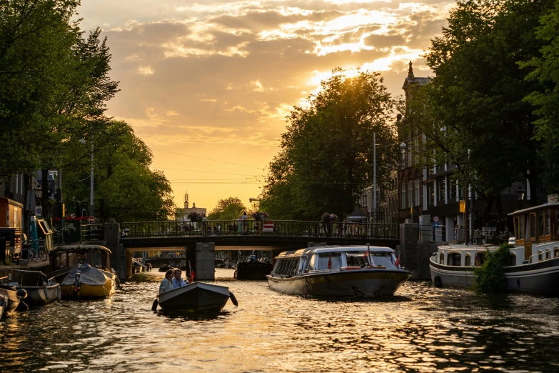 some boats are floating on the river as the sun rises