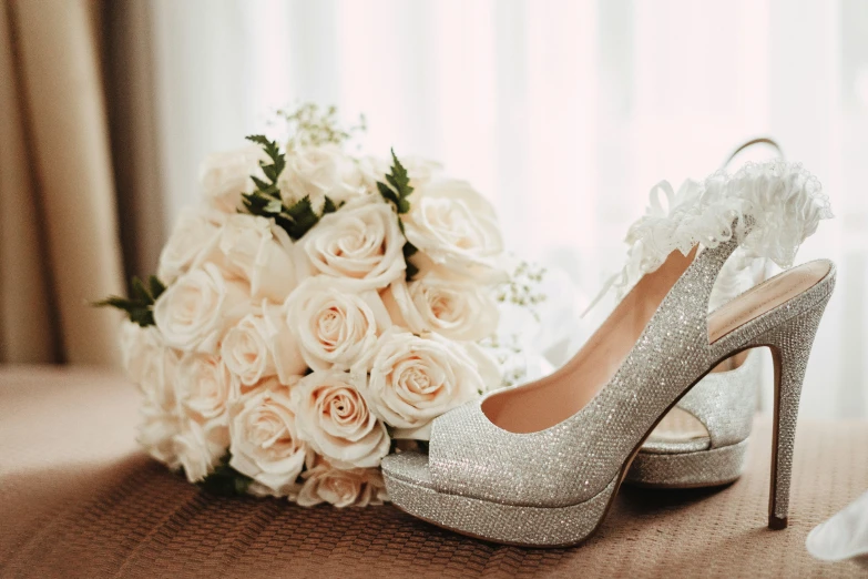 wedding shoes with a bouquet of flowers on the floor