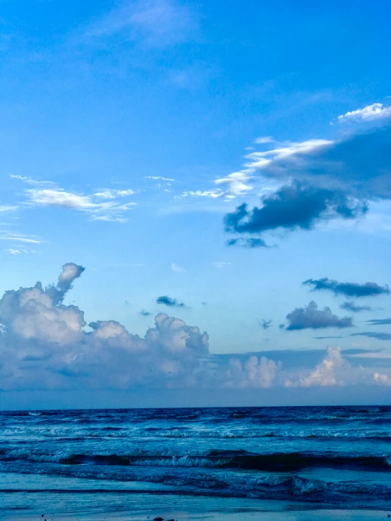 a boat sailing in the water under some clouds