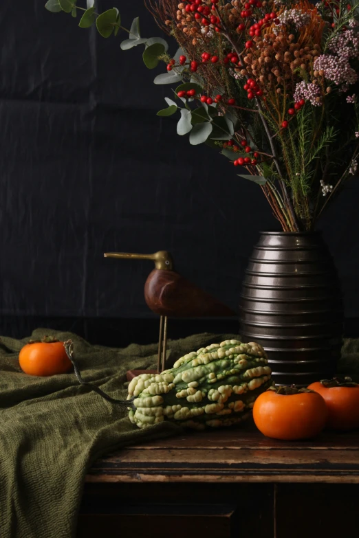 a vase of flowers and a bird sitting on a table