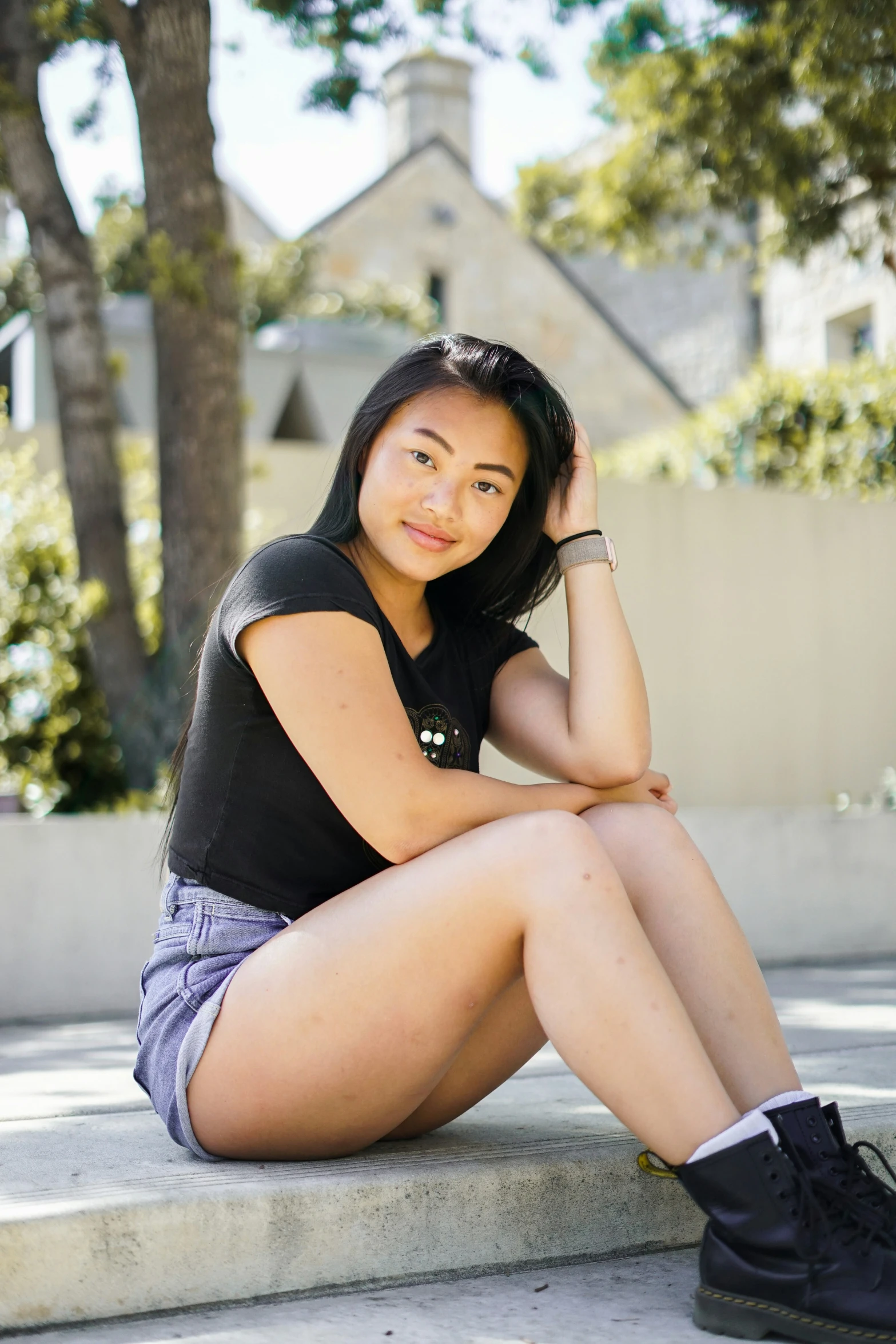 young asian girl sitting on concrete steps in front of a house