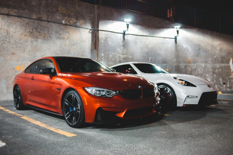 two bmws in the parking lot at night
