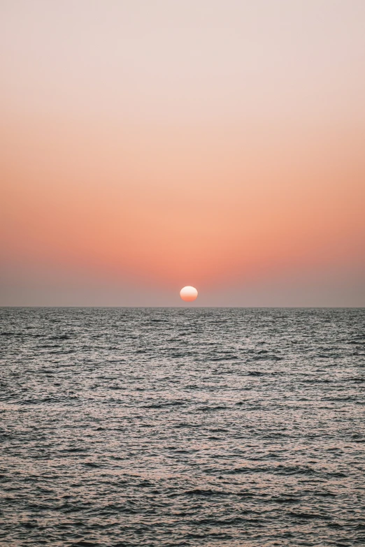 a body of water with a red sky in the background