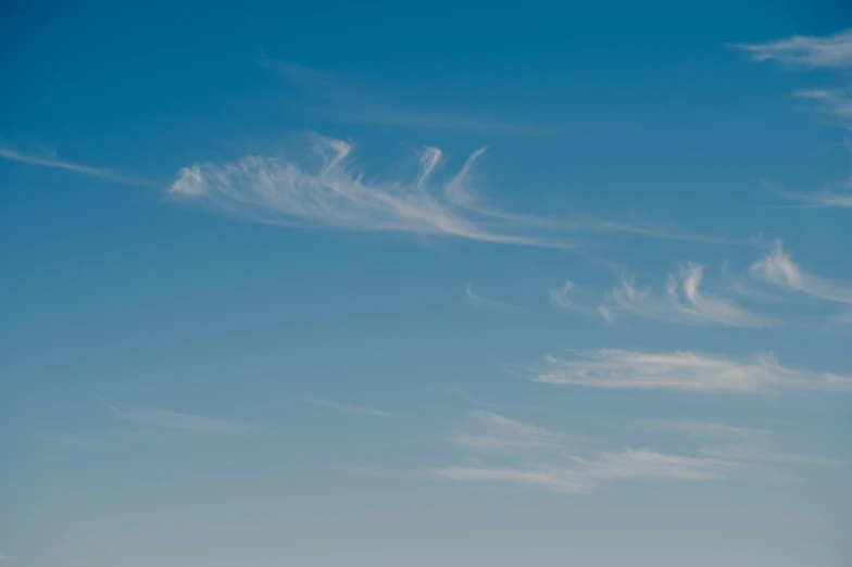 a airplane flying in the air on a cloud filled day