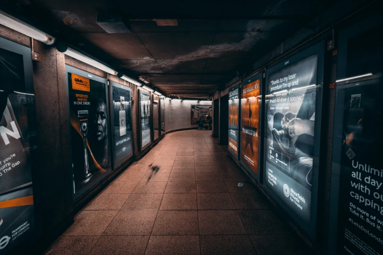 a long sidewalk with lights on and posters along it