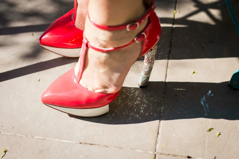 a woman's feet wearing red heels with sparkles