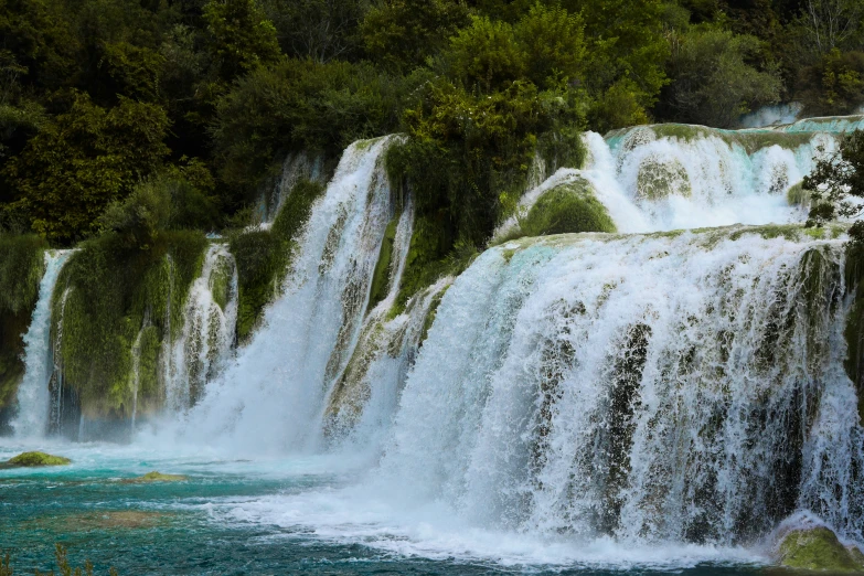 large waterfall near a river and several smaller waterfalls in the background