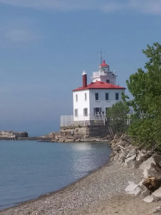 a white lighthouse sitting in the middle of the ocean