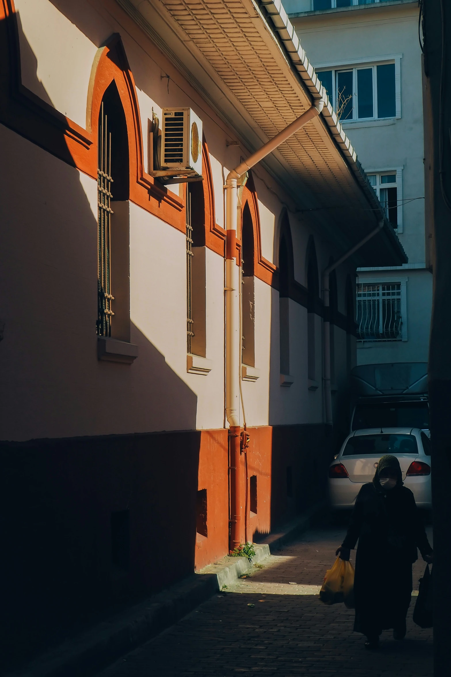 people walk through an alley between buildings