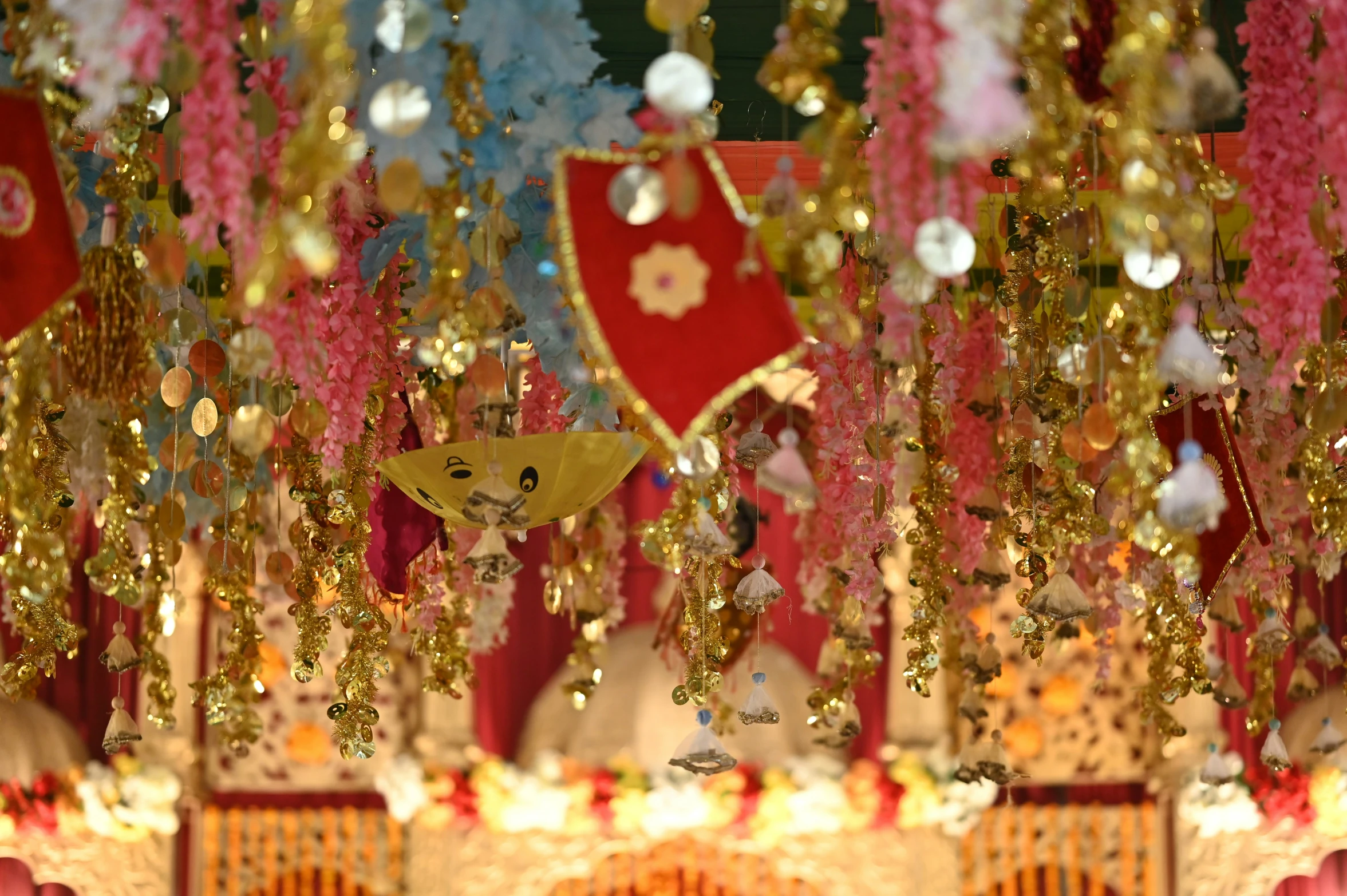 some pink and yellow decorations hanging in the air