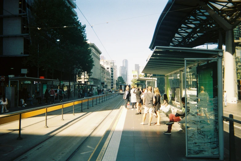 people wait for a train to pull into the station