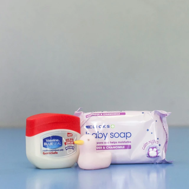 a baby soap, diaper and cream sitting on top of a table
