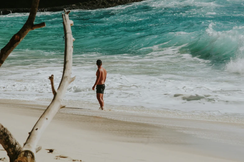 a man standing on top of a beach near a body of water