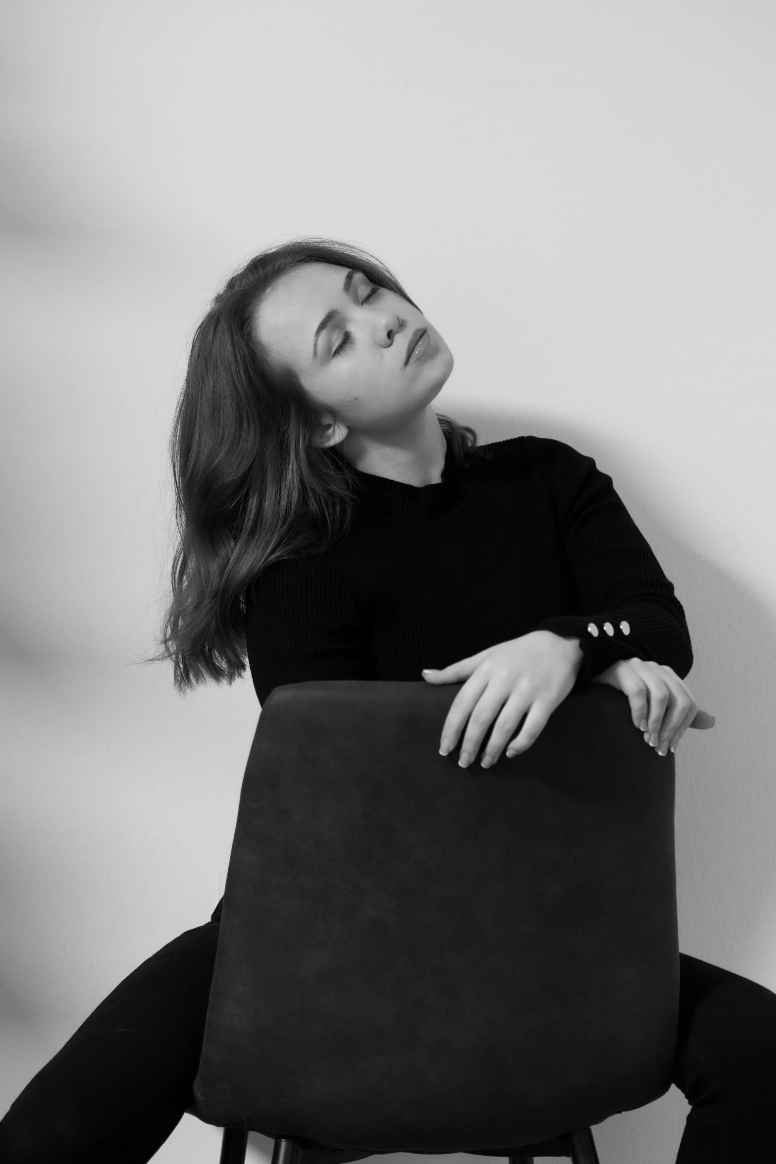 a black and white pograph of a woman sitting in a chair