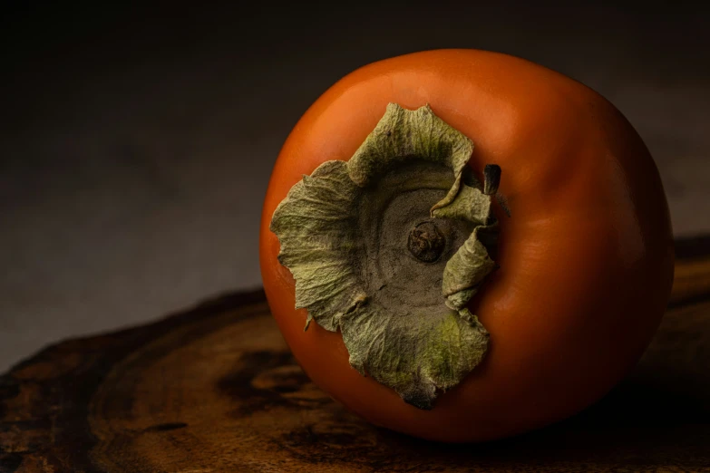 a ripe tomato sits on the edge of a  board