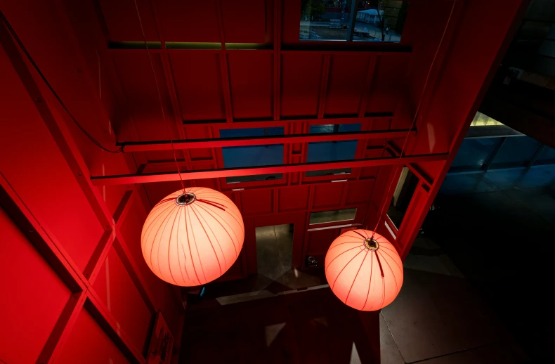 two orange lanterns are hanging in a room