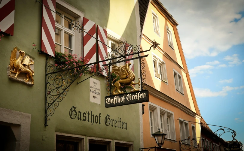 a row of buildings with hanging flags and other signs