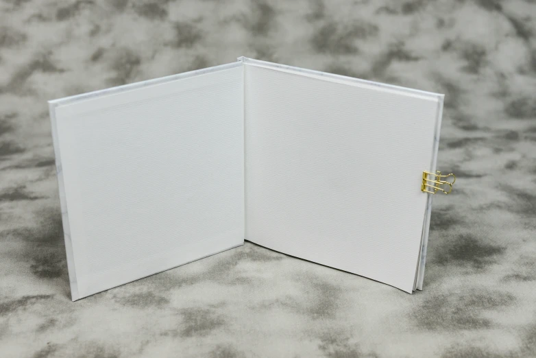 a white folder on top of grey fabric with a yellow ring