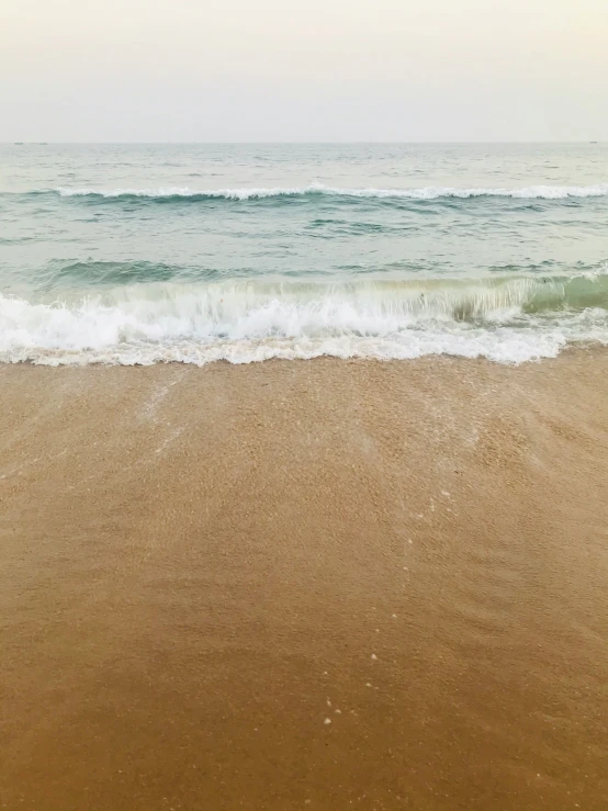 the water is crashing on the beach and sand