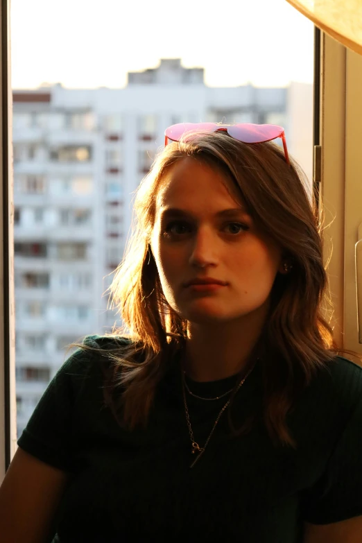 a girl wearing sunglasses looks out of the window