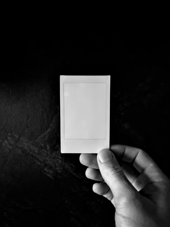 a person holding a white square in their hand