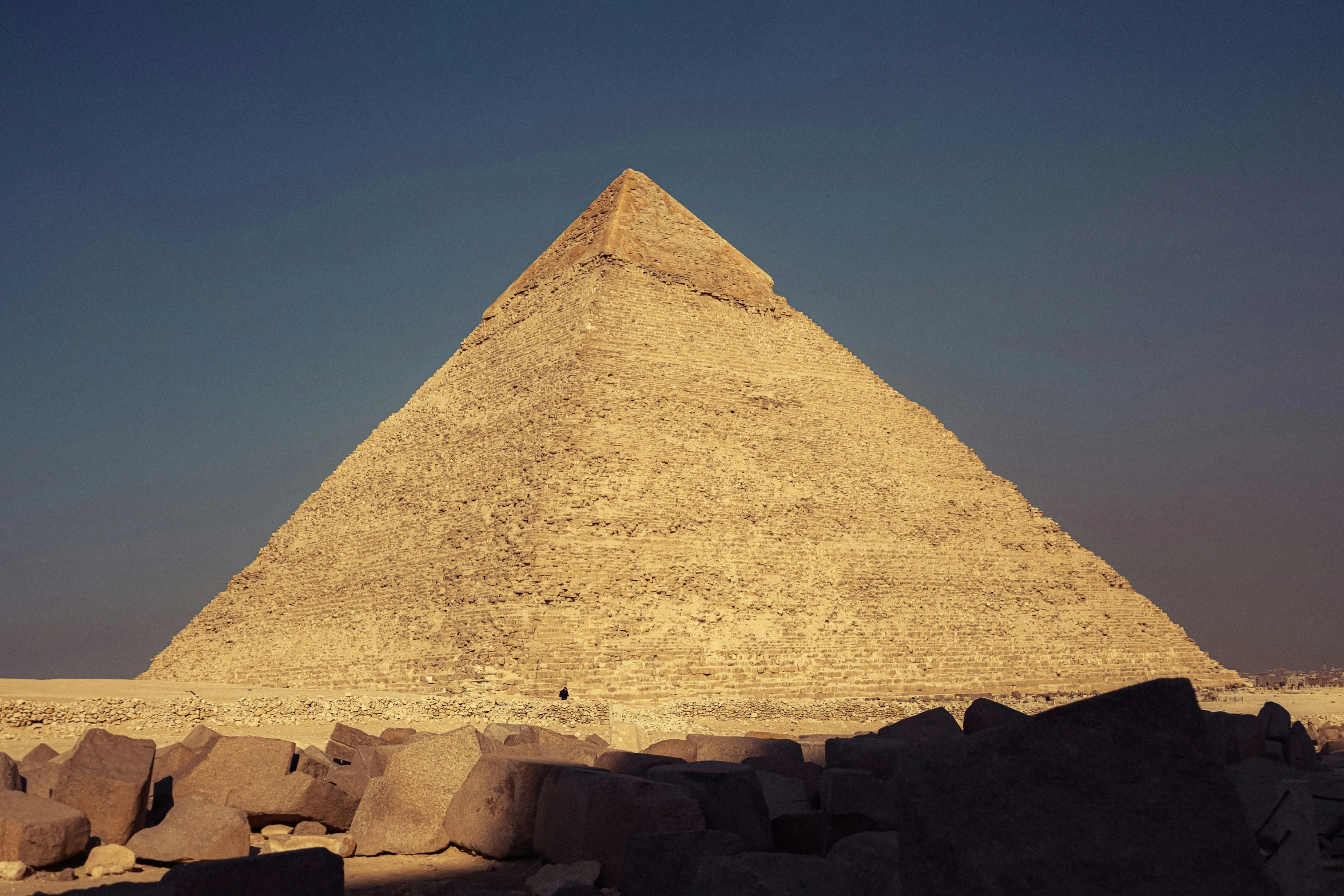 a large stone pyramid sitting next to a tall wall