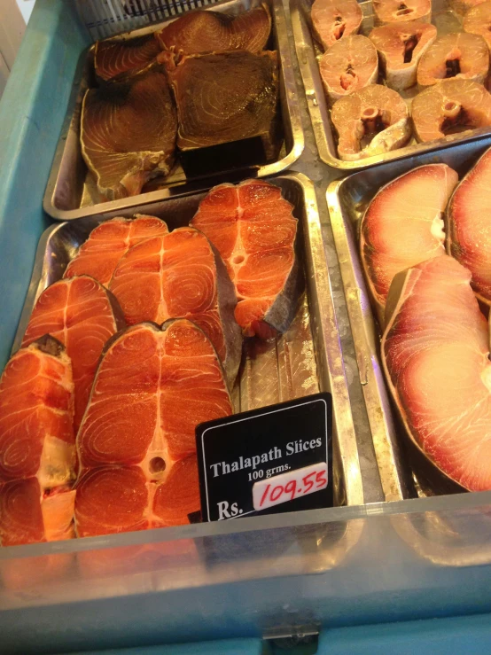 seafood displayed in trays at a fish market