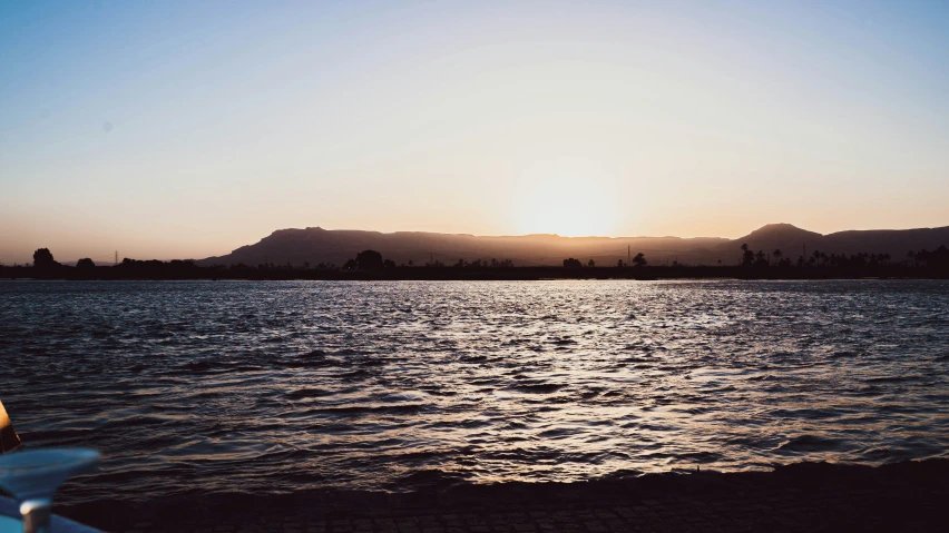 the sun is shining on a clear day over a body of water