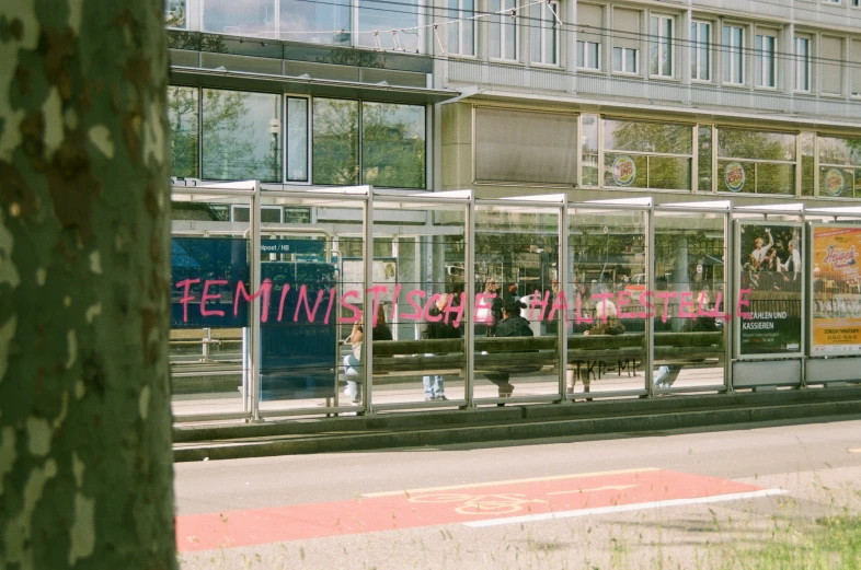 a woman stands next to the entrance of an office building with pink written in it