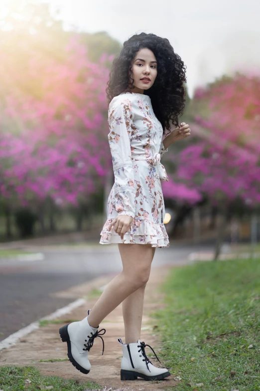 a woman with long black hair and shoes on standing in a sidewalk