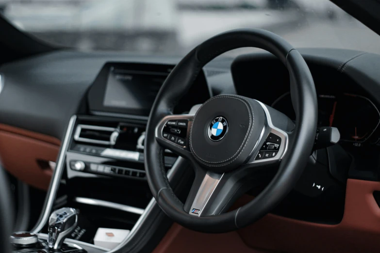 a car dashboard with a steering wheel and brown dashboard