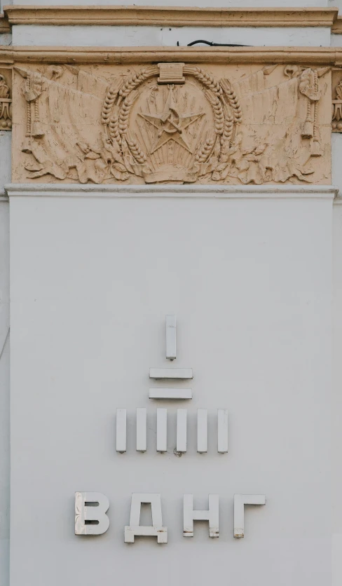 a white building with a large carved sculpture above it