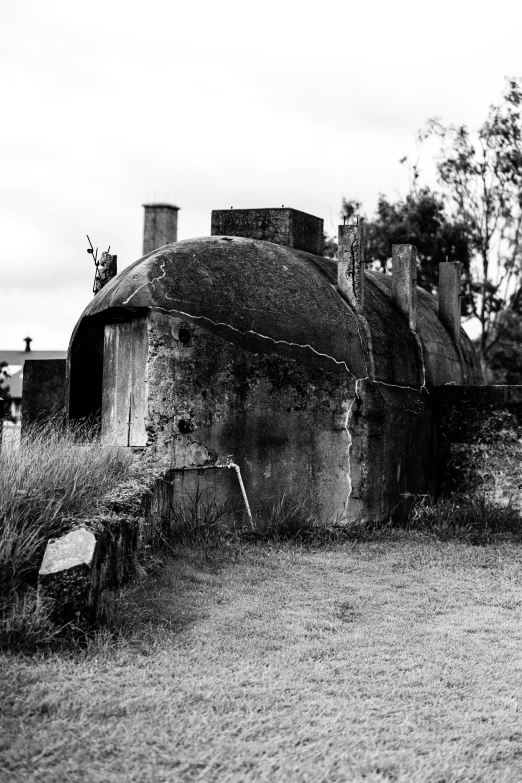 an old cement building on the grass