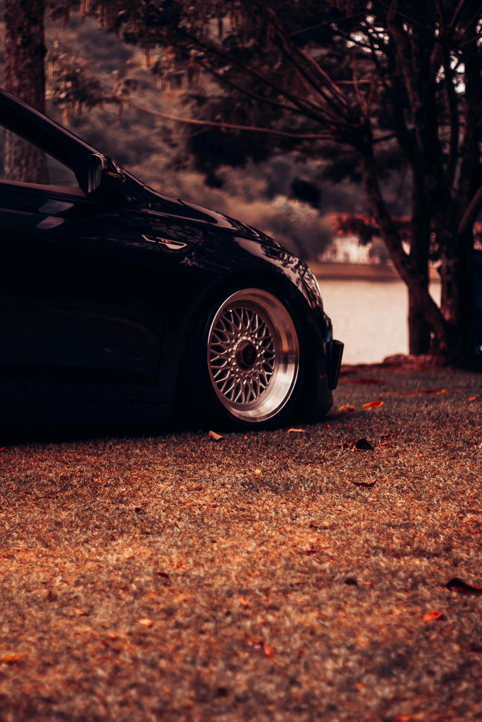 a black car parked in front of some trees