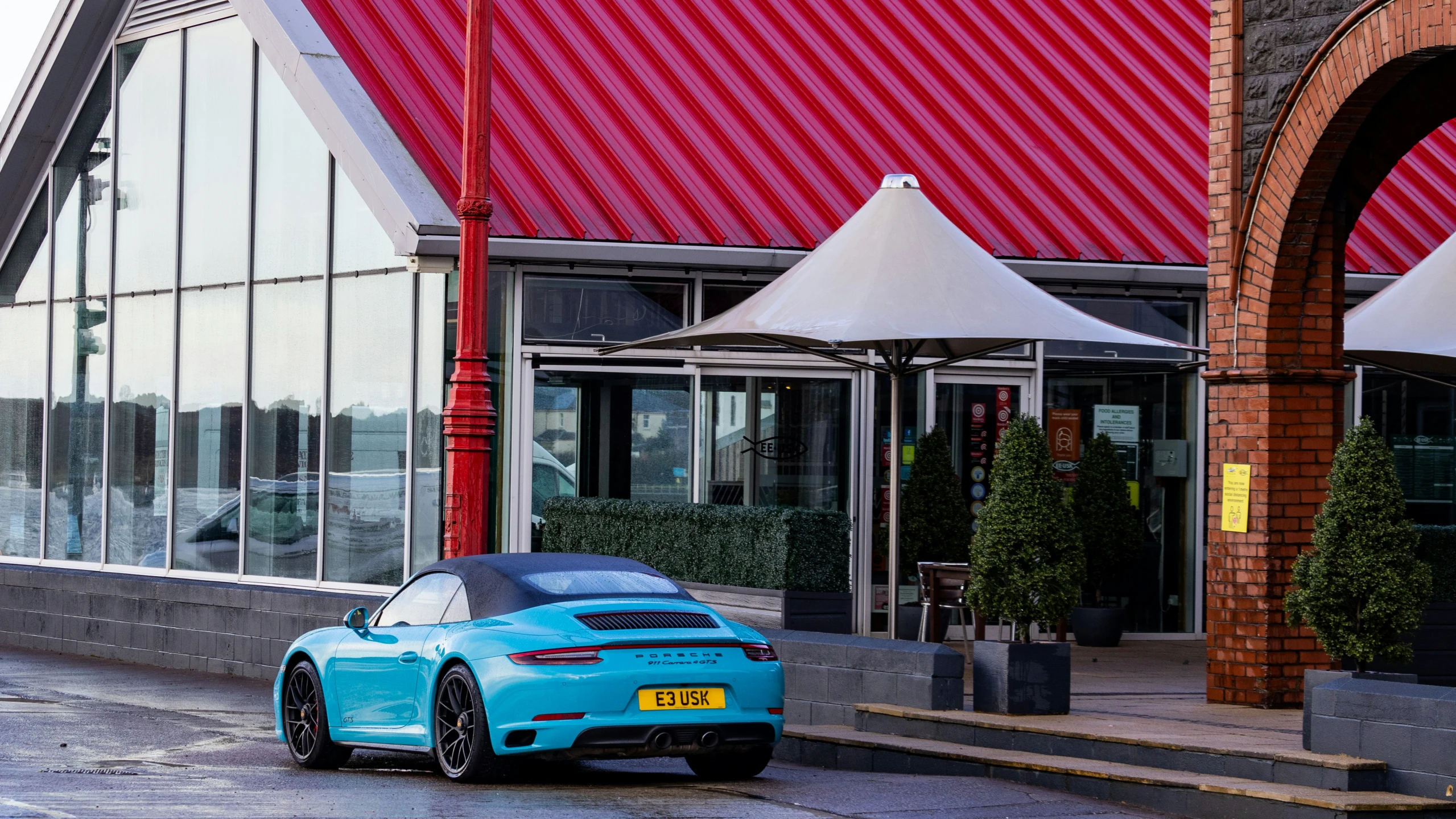 a light blue car parked in front of an outdoor restaurant