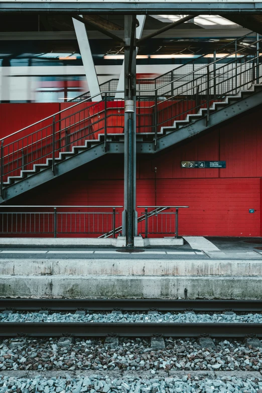 the train runs past an empty station with stairs on either side