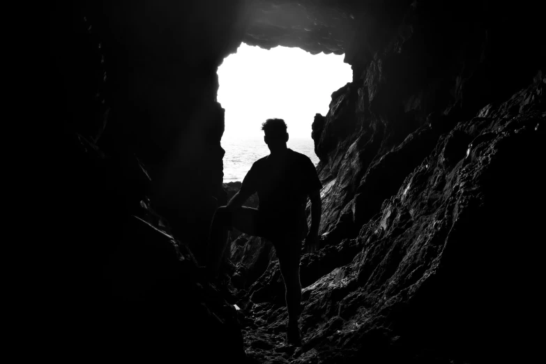 the person is walking away from the light at the end of the cave