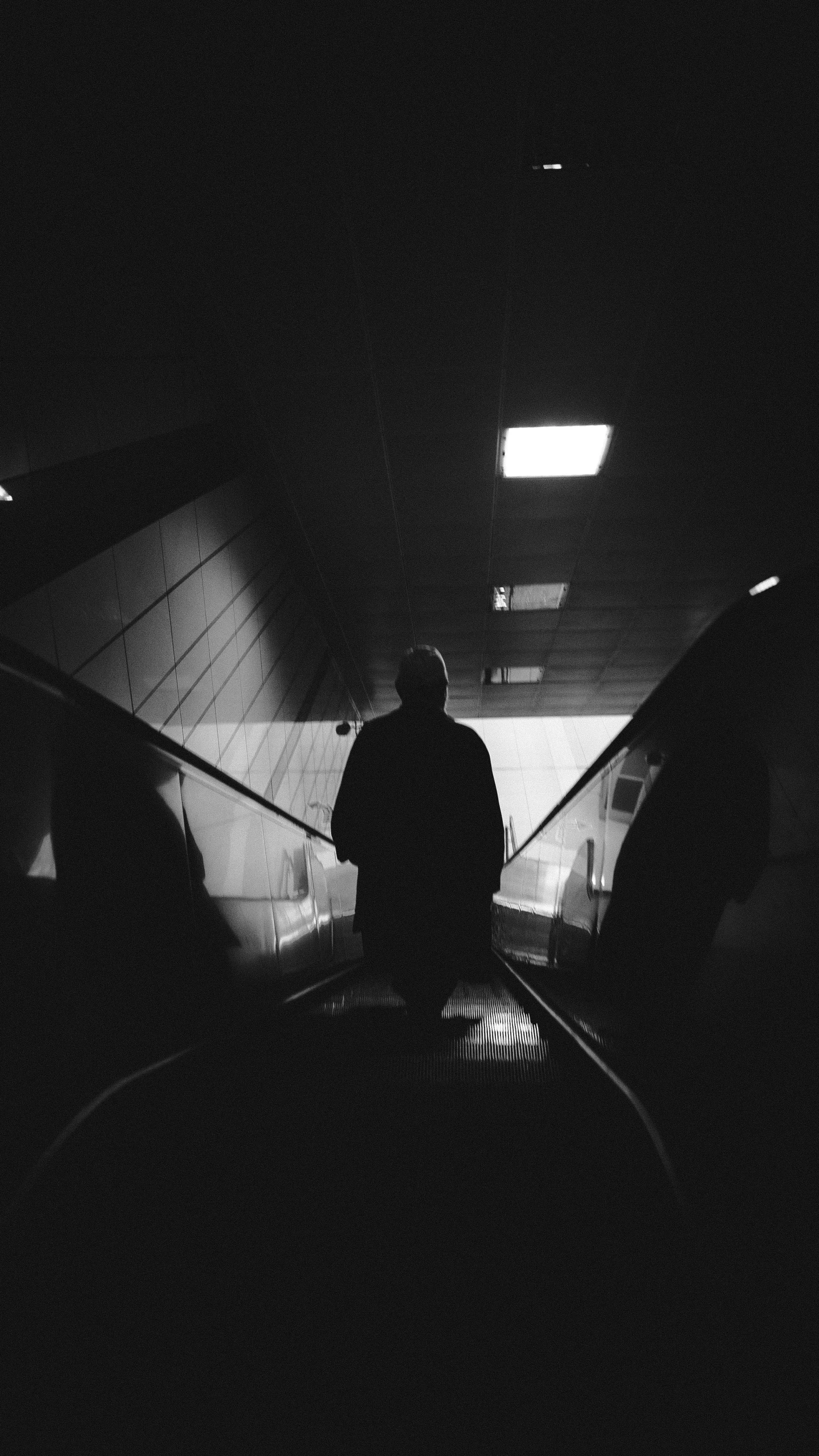 a man walking through a tunnel at night