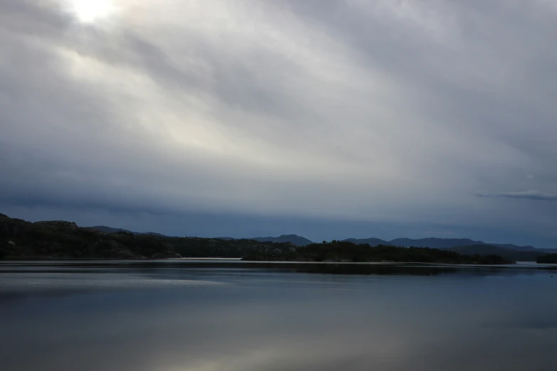 cloudy skies hover over a calm body of water