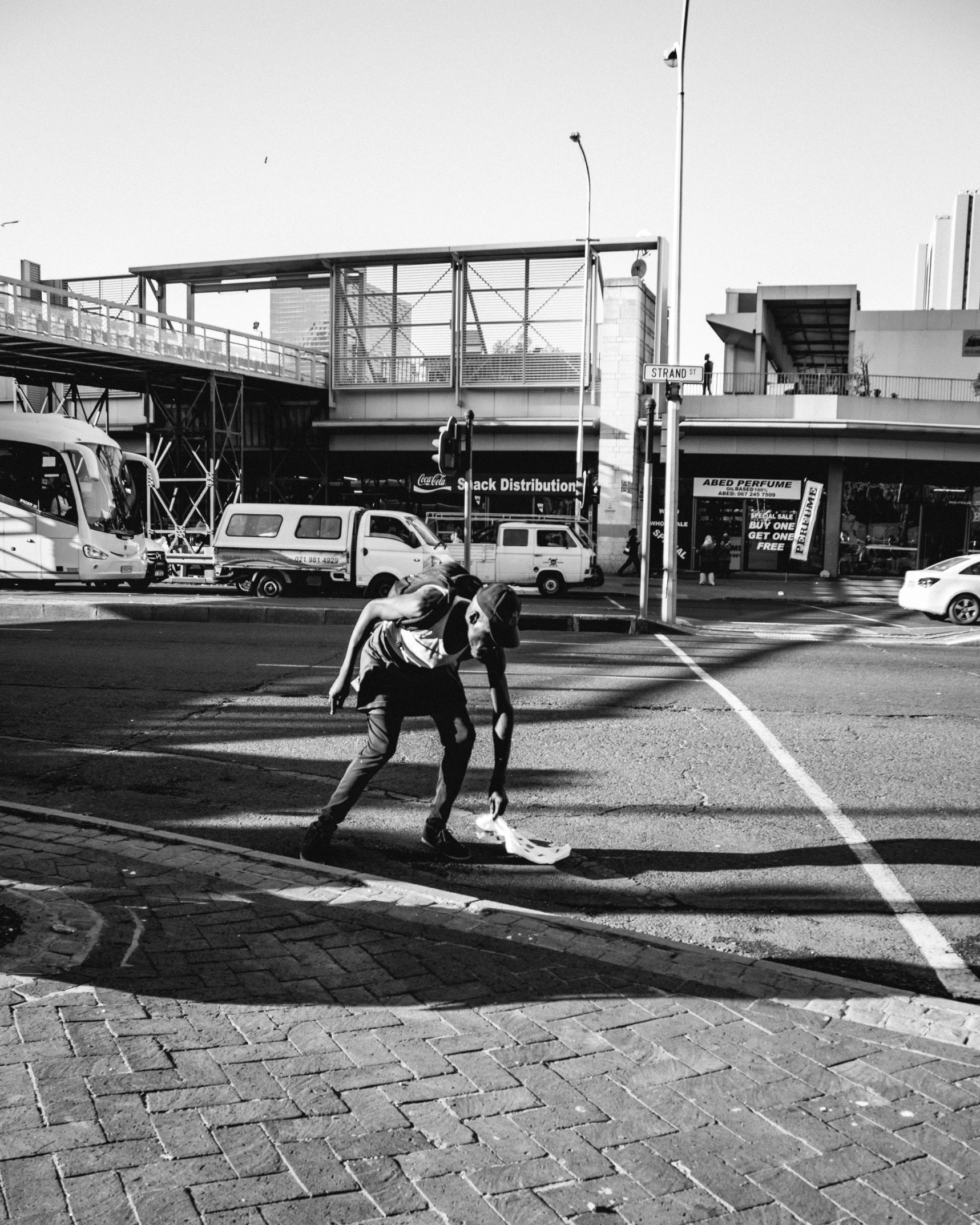 people are walking in a street under a bridge