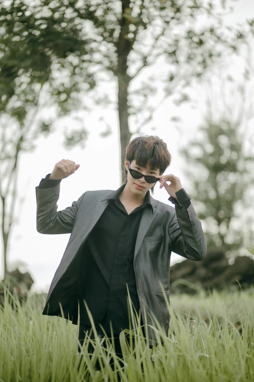 a young man is walking through the tall grass