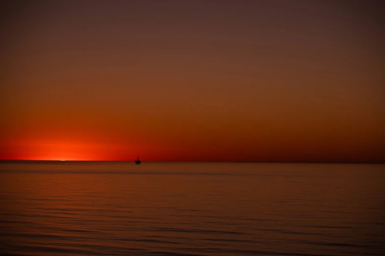 the sun setting over an ocean on a bright day