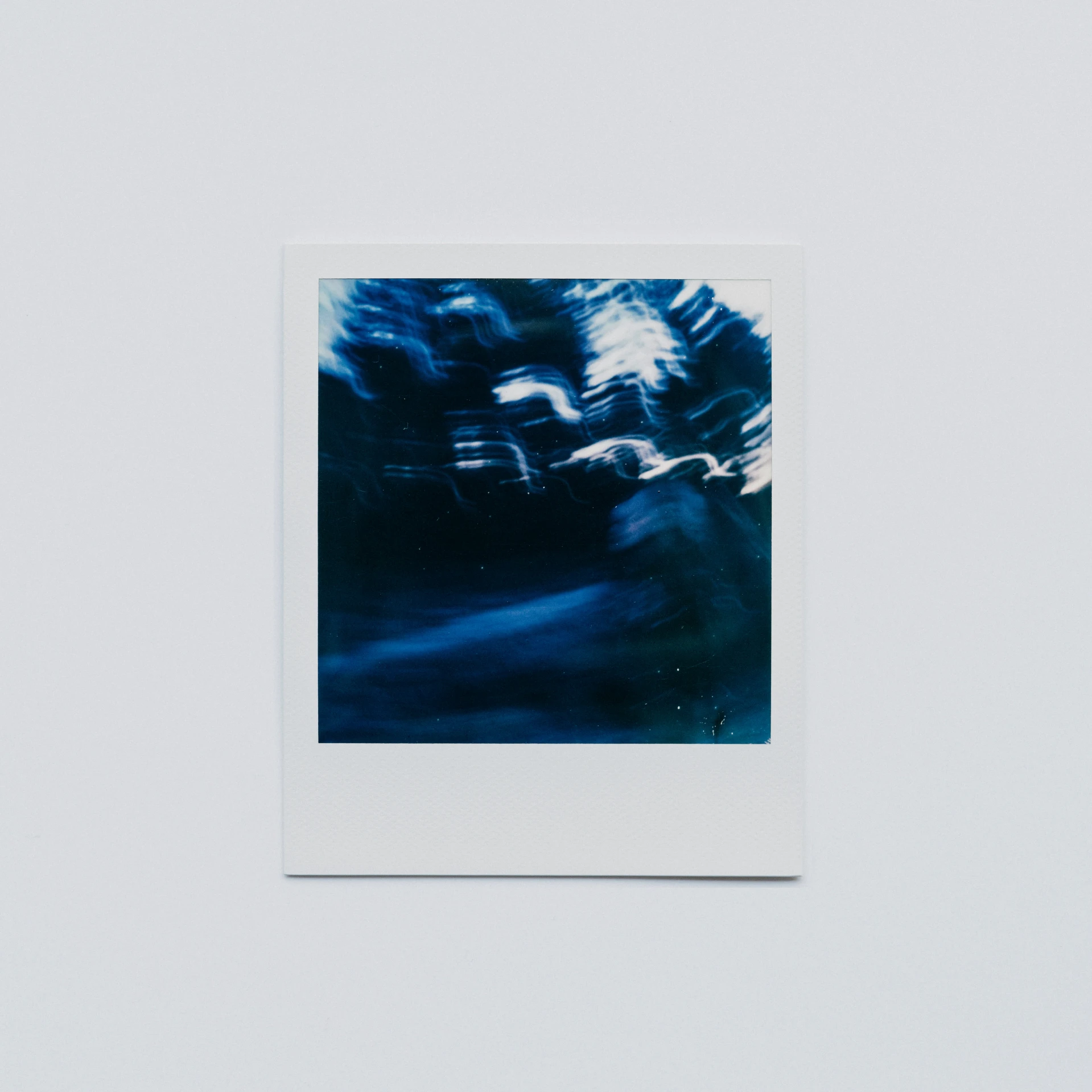 a polaroid with some dark blue water in it